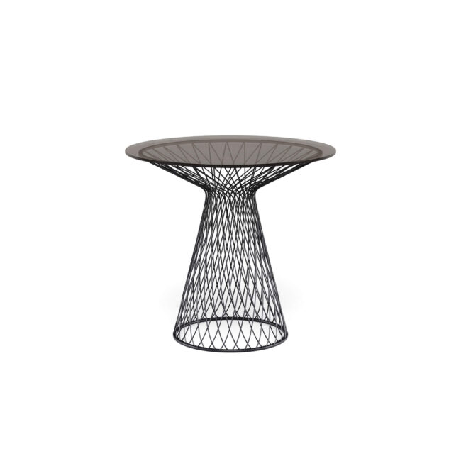 Il tavolo tondo Heaven, diametro 80 cm, con piano in cristallo e design di Jean-Marie Massaud, è un inno alla leggerezza e all’eleganza senza tempo. La base, realizzata con profili in acciaio intrecciati e zincati a caldo, disegna un raffinato intreccio di linee e spazi vuoti che cattura lo sguardo e dona al tavolo una silhouette armoniosa e moderna. Il piano in cristallo temperato, disponibile in due diverse colorazioni, aggiunge un tocco di luminosità e leggerezza, rendendo l’ambiente ancora più raffinato. Heaven trasforma ogni spazio in un luogo elegante e accogliente, dove design contemporaneo e leggerezza si fondono in perfetta armonia, diventando protagonista di ogni momento conviviale.