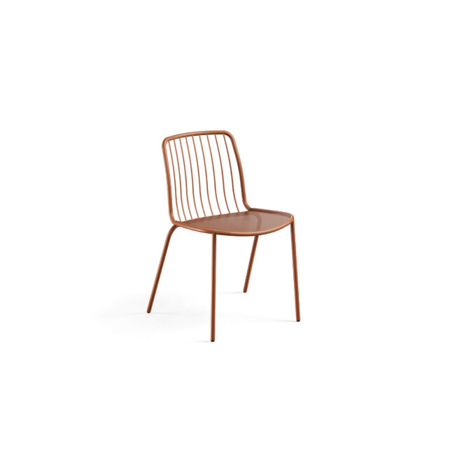 La sedia Alisea in acciaio è una soluzione di design pensata per l’arredo contract outdoor urbano. Ispirata alla leggerezza del vento, unisce funzionalità, resistenza ed essenzialità estetica, risultando ideale per bar, ristoranti, dehors e spazi pubblici. Il sedile in lamiera stirata garantisce traspirabilità e comfort, mentre lo schienale in aste metalliche crea un effetto visivo leggero e dinamico. Il design combina due tecnologie costruttive – barra curva e lamiera stirata – assicurando solidità strutturale e lunga durata anche in ambienti ad alto utilizzo. La vasta gamma di colori consente abbinamenti versatili con stili moderni, industriali o contemporanei.